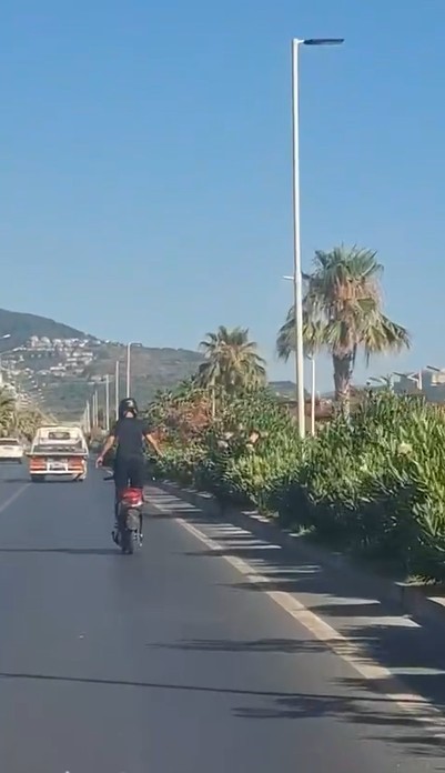Alanya&rsquo;da motosiklet &uuml;zerinde ayakta ilerleyen s&uuml;r&uuml;c&uuml;n&uuml;n tehlikeli yolculuğu kamerada
