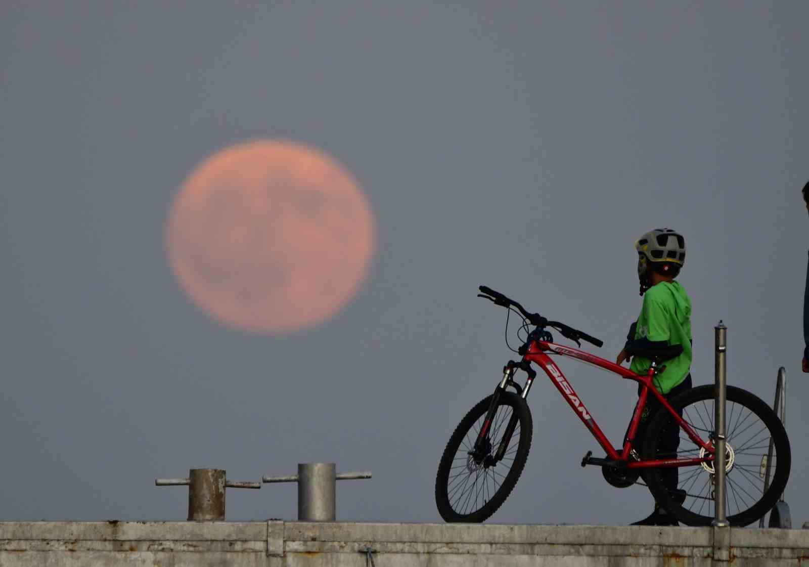 Dolunay ile insanların siluetleri aynı karede

