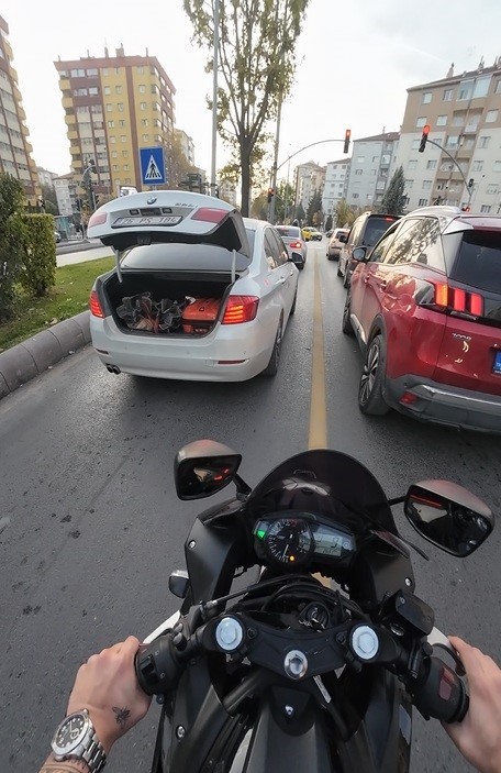 Trafikte bagajı açık kalan aracın yardımına motosiklet sürücüsü yetişti
