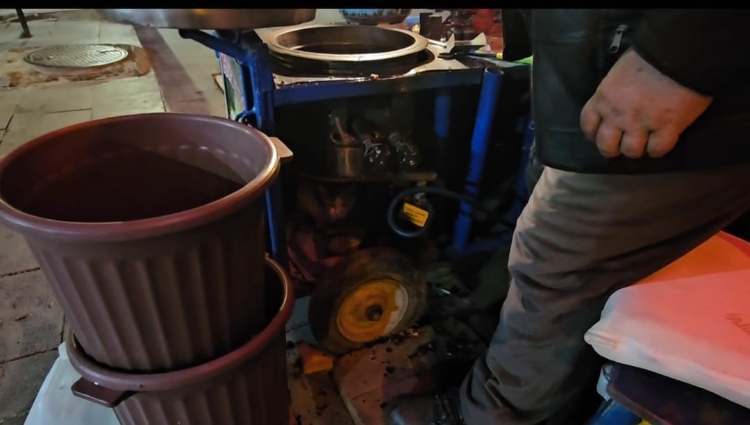 Sokak kedisine &uuml;ş&uuml;mesin diye kestane kazanının yanında bakıyor
