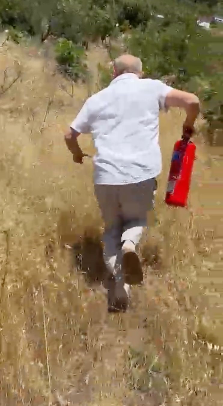 Yangını görüp aracındaki yangın tüpüyle muhtemel orman yangınının önüne geçti