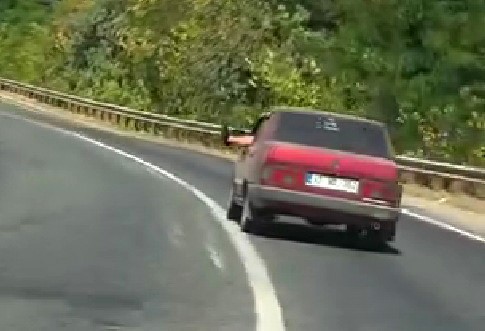 Ayaklarını camdan sarkıtarak trafiği tehlikeye attı